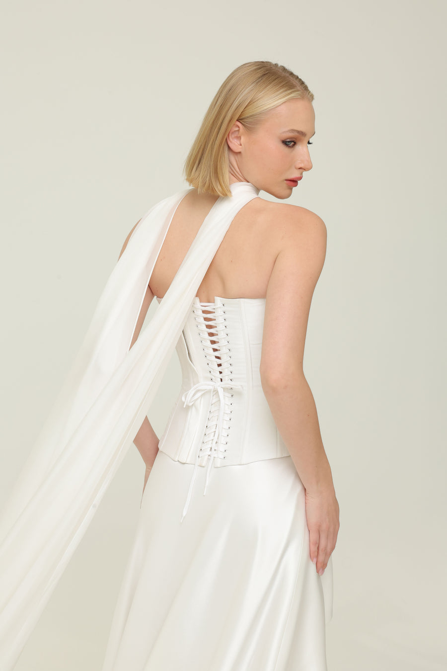 back view of second wedding dress, featuring the back corset detailing and scarf. rent the latest at klovia 